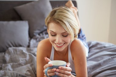 Mutlu gülümseyen güzel sarışın kadın fincan kahve ile kirlenmiş