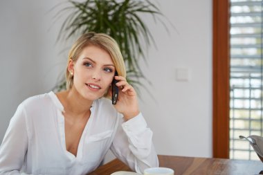 Cep telefonuyla konuşan mutlu genç bir kadın.