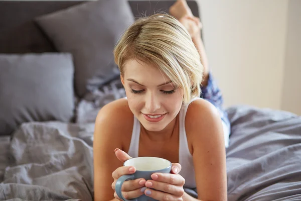 Glada leende vacker blond kvinna vaknade med kopp kaffe — Stockfoto