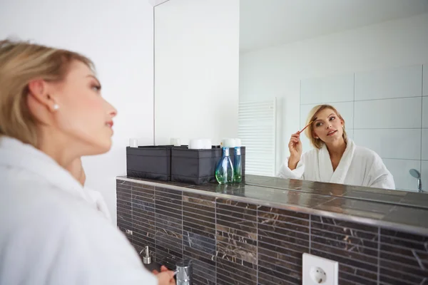 Portrait of attractive young adult woman applying blusher — Stock Photo, Image