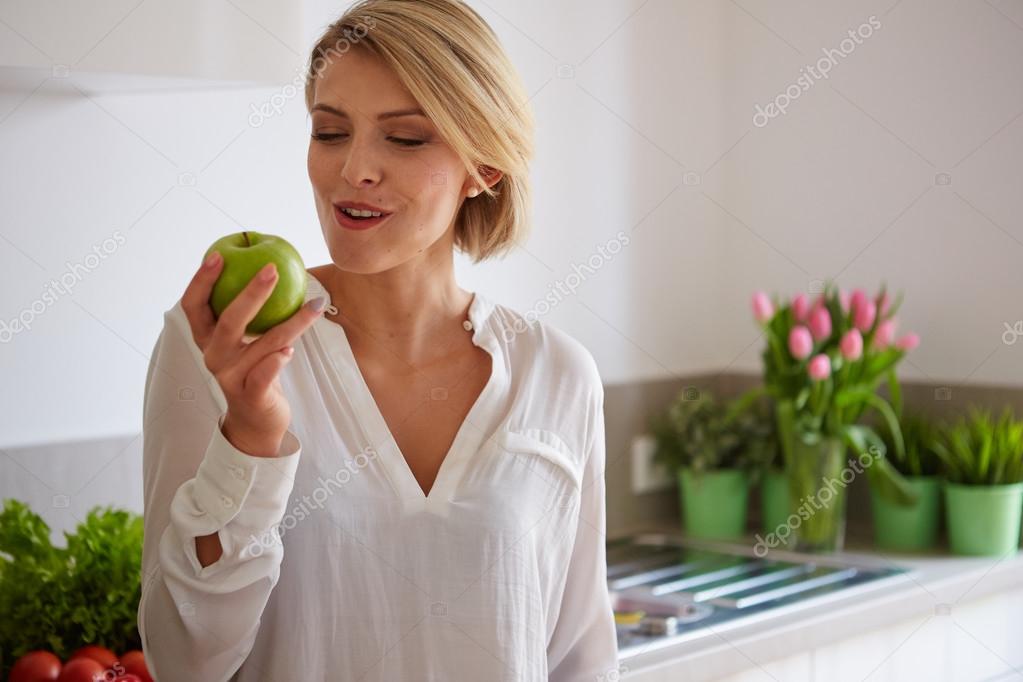 Happy young woman eating apples — Stock Photo © 2mmedia 68876383