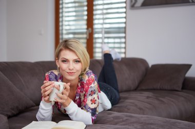 evde kitap okurken zevk kadın kanepede yatıyor
