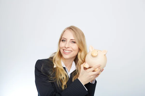 Geschäftsfrau hält Sparschwein. — Stockfoto