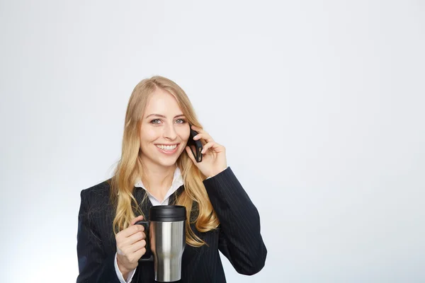 Beautiful caucasian businesswoman talking on phone holding a coffee — Stock Photo, Image