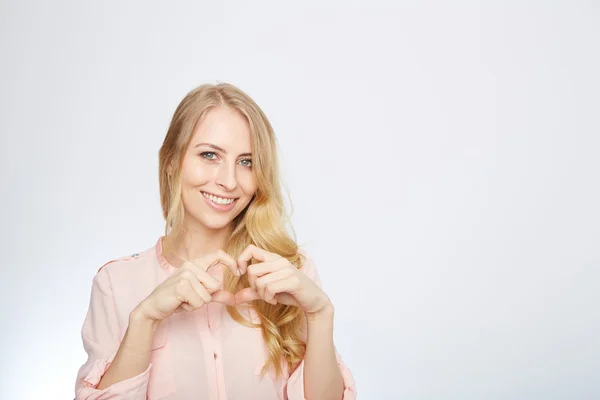 Joven mujer rubia haciendo un símbolo del corazón — Foto de Stock