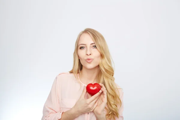 Jeune femme blonde tenant un cœur rouge. isolé sur blanc . — Photo
