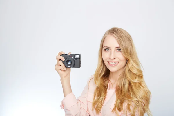 Giovane donna bionda con una fotocamera vintage — Foto Stock