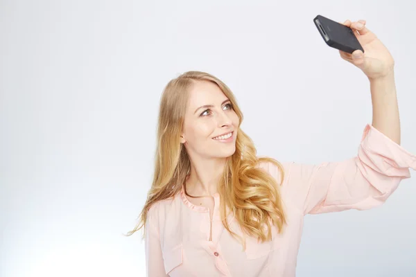 Chica con un teléfono inteligente. aislado en blanco . — Foto de Stock