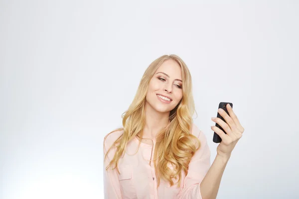 Chica con un teléfono inteligente. aislado en blanco . — Foto de Stock