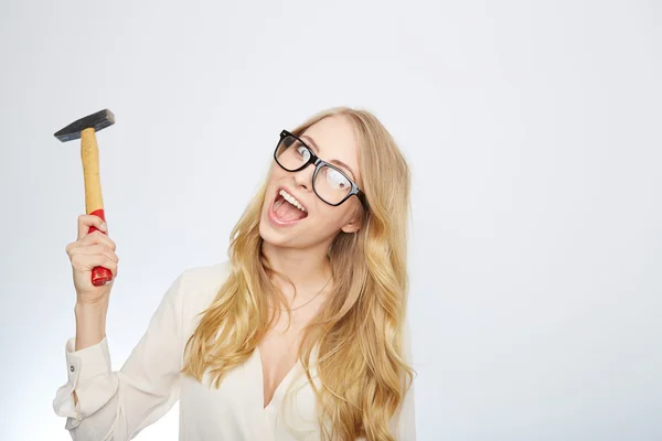 Chica con un martillo y gafas nerd. aislado en blanco — Foto de Stock