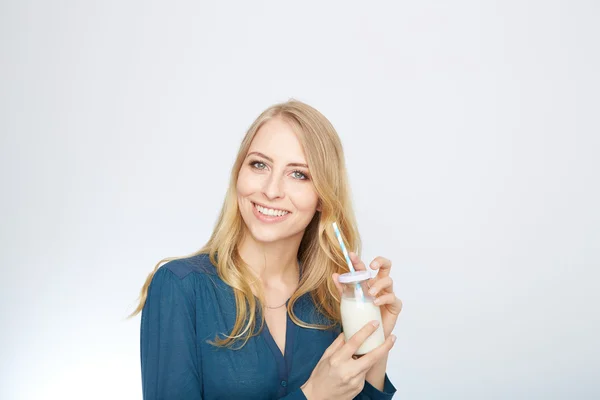 Bonita mujer sostiene vaso de leche deliciosa y pasteurizada — Foto de Stock