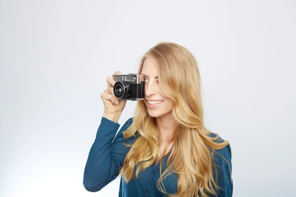 Giovane donna bionda con una fotocamera vintage — Foto Stock