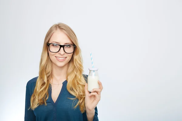 Bonita mujer sostiene vaso de leche deliciosa y pasteurizada — Foto de Stock