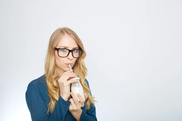 Bonita mujer sostiene vaso de leche deliciosa y pasteurizada —  Fotos de Stock