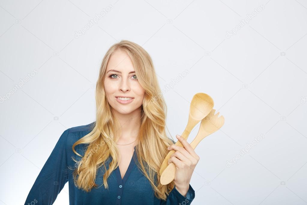 young woman holding a wooden spoon, isolated.