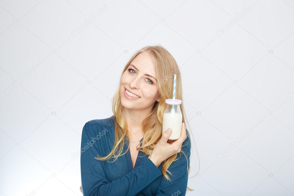 pretty woman holds glass of delicious and pasteurized milk