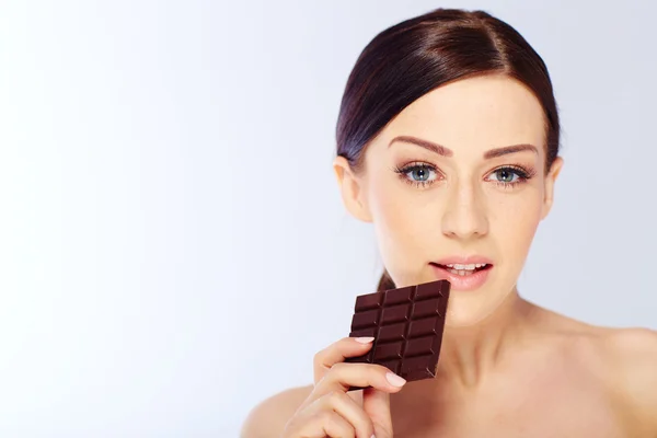 Woman with a chocolate in hand — Stock Photo, Image