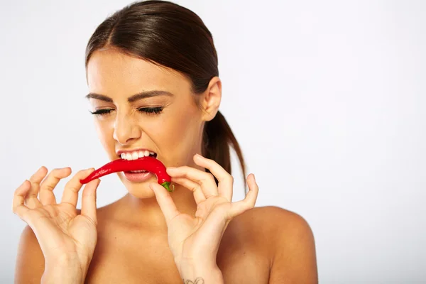 Beautiful caucasian topless woman with chili pepper in mouth. — Stock Photo, Image