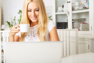 sevimli kadın onu laptop kullanırken çay sahip 