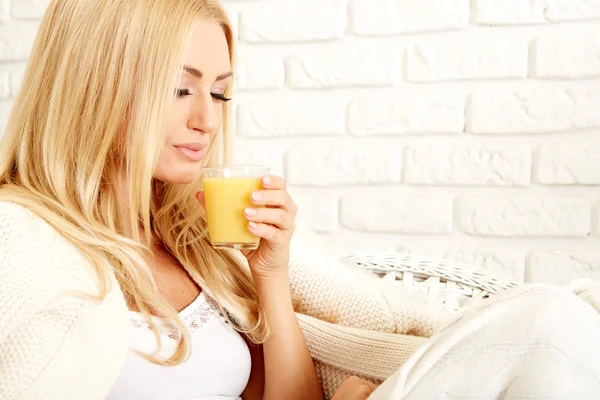 Primo piano di una donna sorridente con succo d'arancia — Foto Stock