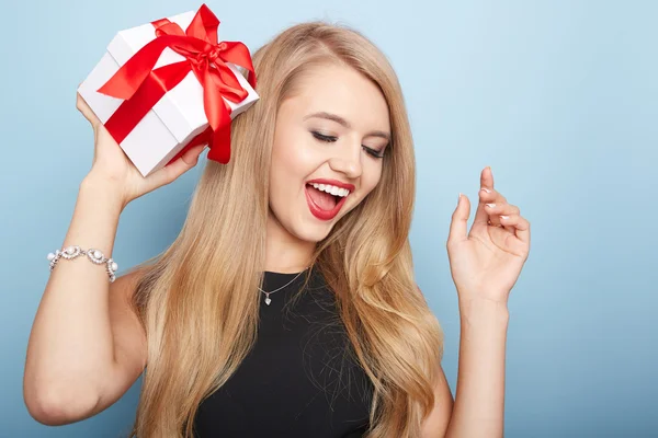 Young woman puts her ear to the present wrapped. — Stock Photo, Image
