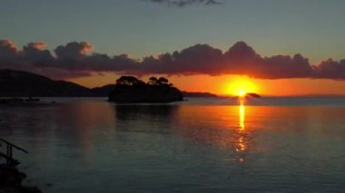 Laganas, Zakynthos sahilinin hemen dışında bulunan Cameo Adası 'nın üzerinde gün doğumunun hızlandırılması.