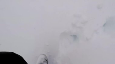 Bir insanın bakış açısıyla derin karda dağ botlarıyla yürümek..