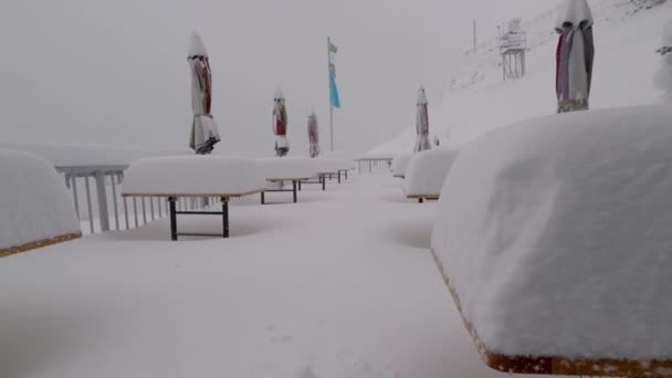 白雪覆盖的平台 雨伞和被厚厚的积雪覆盖的桌子 — 图库视频影像