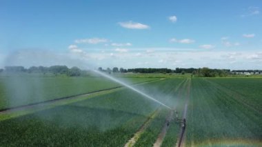 Çifte gökkuşağı tarımsal püskürtücüde görülebilir. Sulama fıskiyesi veya Sektör fıskiyesi ekinleri suluyor