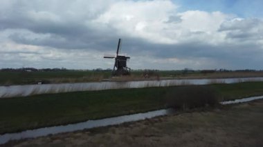 Hollandalı bir yel değirmeninin üzerinden uçuyor. Arazi konsolidasyonunun arkasındaki değirmen manzarası.