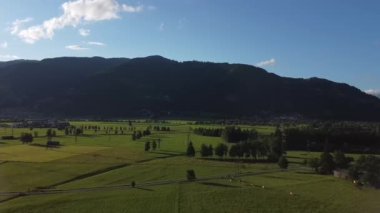 Gün batımında Avusturya, Kaprun 'daki kilise kulesinin yanından geriye doğru uçuyor.