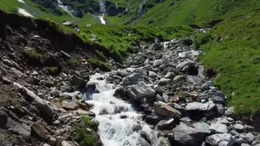 Avusturya 'da bir su akıntısı üzerinde bir sürü kayayla alçaktan uçuyor.