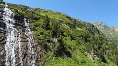 Avusturya Alplerinde güzel bir şelalenin yanından uçarak geçmek. Weissee 'nin onayı