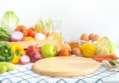 Mutfak tezgahının üzerinde kesim tahtası olan çeşitli sebzeler. Vejetaryen konseptlerle sağlıklı beslenme. Ürün gösterisi için.