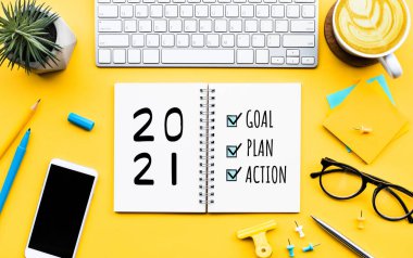 2021 yeni yıl hedefi, planı, ofis aksesuarlarıyla birlikte not defterine eylem metni. İş yönetimi, ilham fikirleri