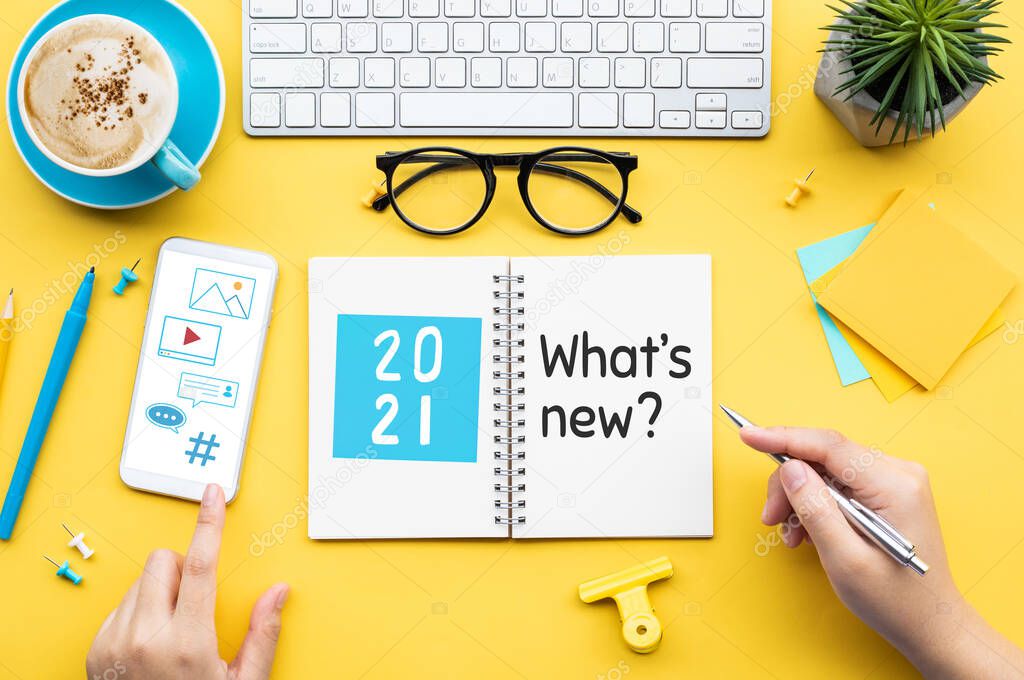 2021 What's new ? or trendy concepts with young person writing text on notepaper and office accessories.Business management,Inspiration concepts ideas