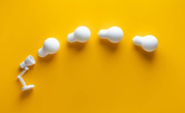 Sarı arka planda lambadan gelen ampul hareketiyle kıvılcım fikri. İş yaratıcılığı.