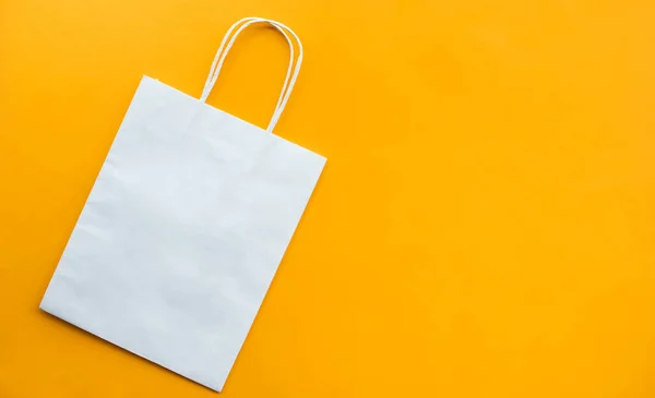 Shopping concepts with white bag paper on on yellow background.copy space