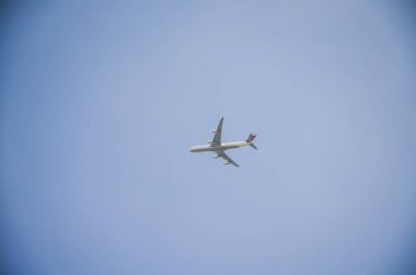 Güneşli mavi gökyüzünde uçan yolcu uçağı 