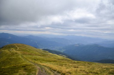 Sonbahar Karpatlar 'ındaki Alp otlağı. Transarpathia 'nın güzel manzarası tepelerdeki kayın ormanları ve uzaktaki muhteşem Svydovets dağ sırtı, Ukrayna 