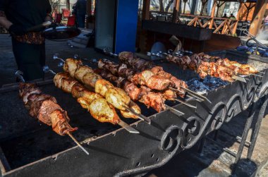 Izgarada baharat karışımı ve dumanın altında metal şiş bulunan iştah açıcı şiş kebap. Geleneksel doğu yemeği, şiş kebap. Kömür ve alevler üzerine ızgara, piknik, sokak yemekleri.