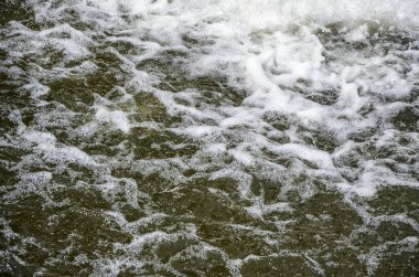 Nehir yüzeyinde beyaz köpük gösteren bir su damlası. Doğal ortam, arkaplan veya doku kavramı