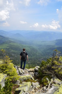 CARPathan Dağları, UKRAINE 08 Haziran 2014: Dağların ve ormanların arka planında duran adam yürüyüşçüsü. Karpatlar, Gorgany sırtı, Ukrayna manzarası.