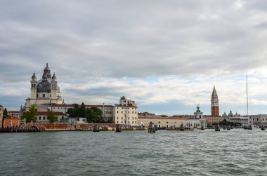 Venedik 'teki San Marco Meydanı' nda, kıyı şeridi boyunca çamurlu havada bir su taksisi teknesinin manzarası.