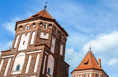 Beyaz Rusya, MIR 'de ortaçağ kalesi. Yaz mevsiminde bulutlu gökyüzünün altındaki kulelerin yan görüntüsü. Ülkenin en ünlü eğlencelerinden biri.