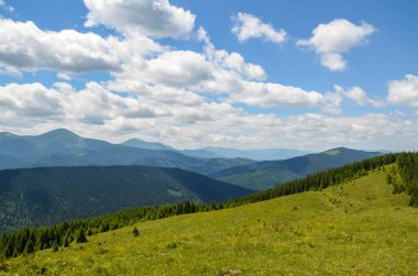 Ormanlık yeşil tepeli güneş ve bulutlar dağ yaz manzarası. Kostrych tepesinden Chornohora sırtına, Karpatya dağlarına, Ukrayna 'ya