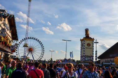 MUNICH, Almanya 23 Eylül 2013: Ekim Festivali 'nde Paulaner kulesinin yanındaki insanlar. Meşhur bira bardağıyla Paulaner kulesinin çatısında.