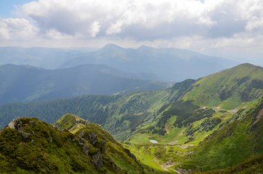 Ufukta tepeler, patikalar ve tepeler olan yaz manzarası sabah Marmarosy sırtı, Karpatya Dağları. Ukrayna.
