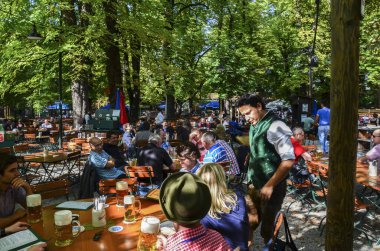 MÜZİK, GERÇEK 23 Eylül 2013: İnsanlar Almanya 'nın Münih kentindeki tipik Alman bira bahçesinde oturuyor, yiyor ve bira içiyorlar