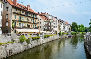 Ljubljana 'nın tarihi merkezinde eski binalarla Ljubljanica nehrinin manzarası. Ljubljana Slovenya 'nın başkenti ve Avrupa' nın ünlü turizm merkezidir.. 